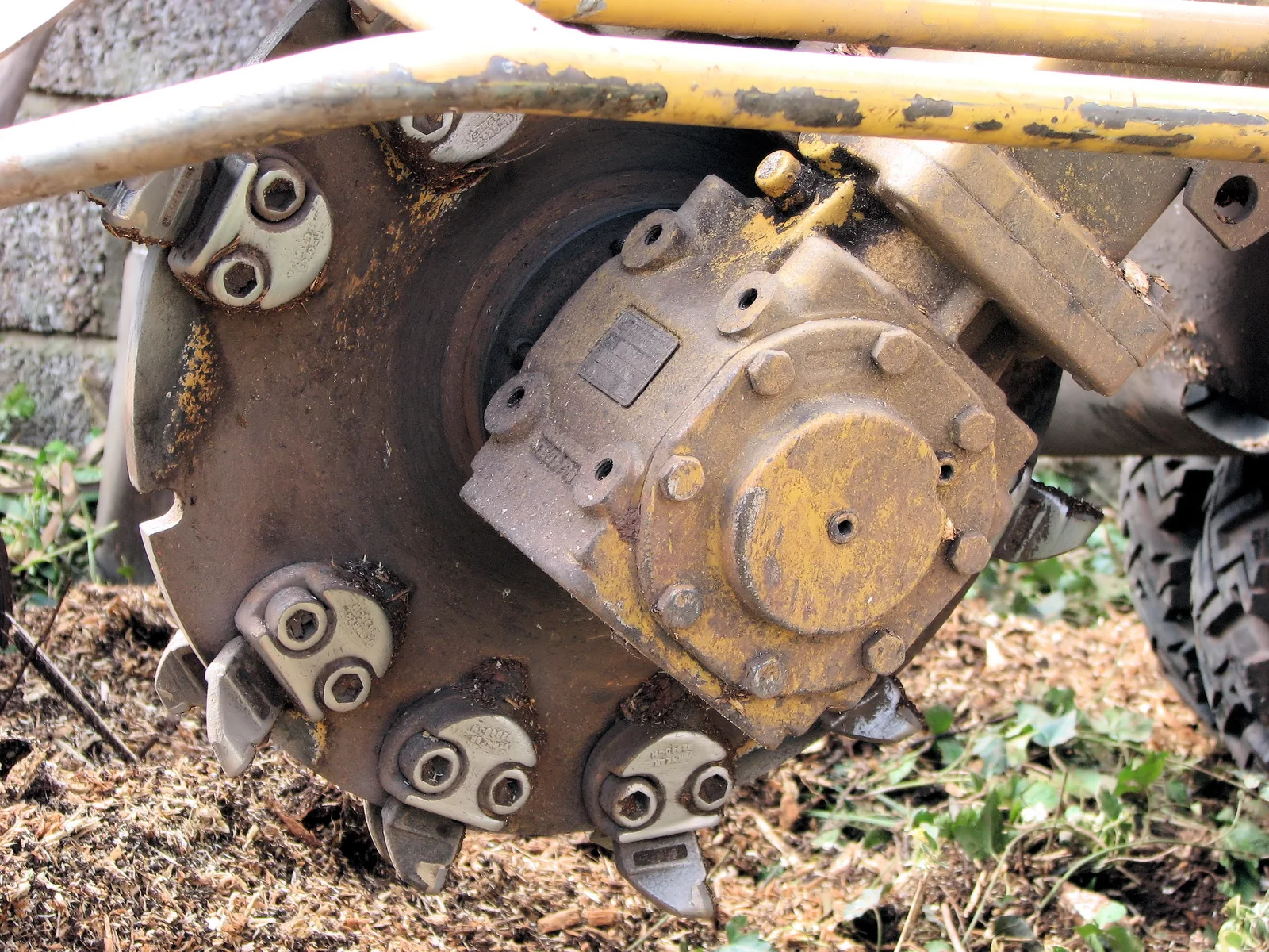 Close-up of a stump grinder cutting wheel and its toothed grinding disc.